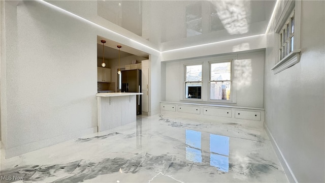 unfurnished living room with baseboards