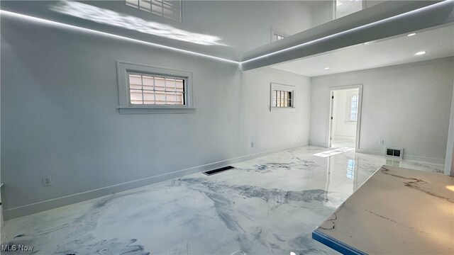 empty room featuring marble finish floor, baseboards, visible vents, and recessed lighting