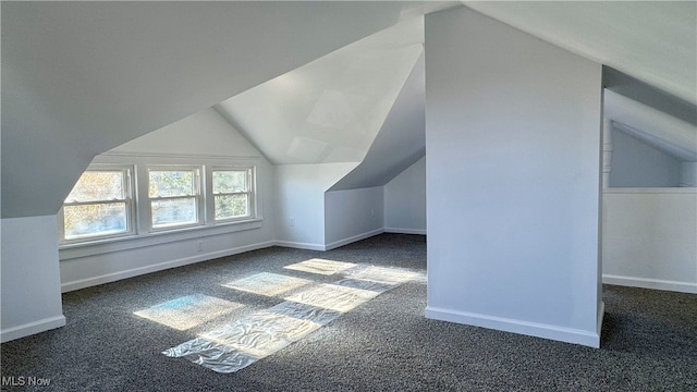 additional living space featuring carpet floors and vaulted ceiling