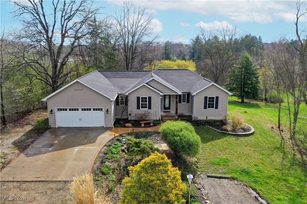 single story home featuring concrete driveway, an attached garage, and a front yard