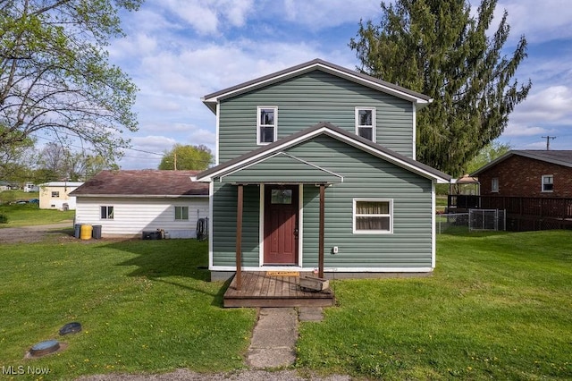 traditional home with a front lawn and fence