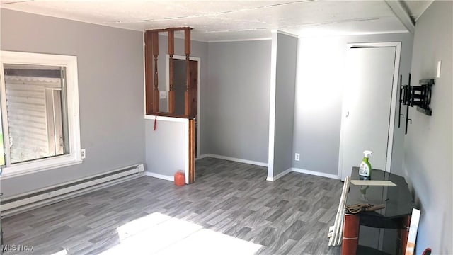 135 Paradise Blvd, Madison, OH 44057 - empty room with a baseboard heating unit, baseboards, and wood finished floors
