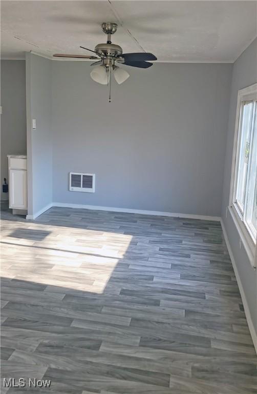135 Paradise Blvd, Madison, OH 44057 - spare room featuring baseboards, visible vents, a ceiling fan, wood finished floors, and crown molding