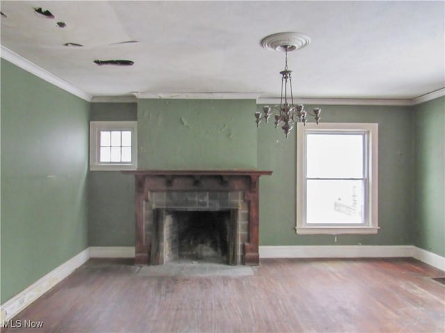 unfurnished living room with baseboards, ornamental molding, a brick fireplace, and wood finished floors