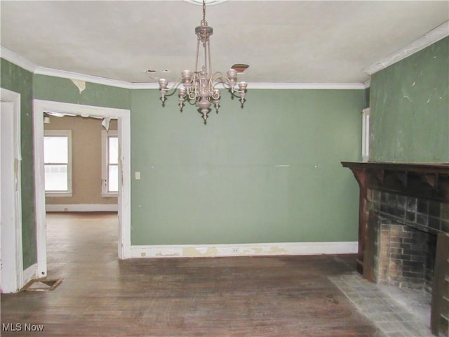 unfurnished living room featuring a chandelier, wood finished floors, and baseboards