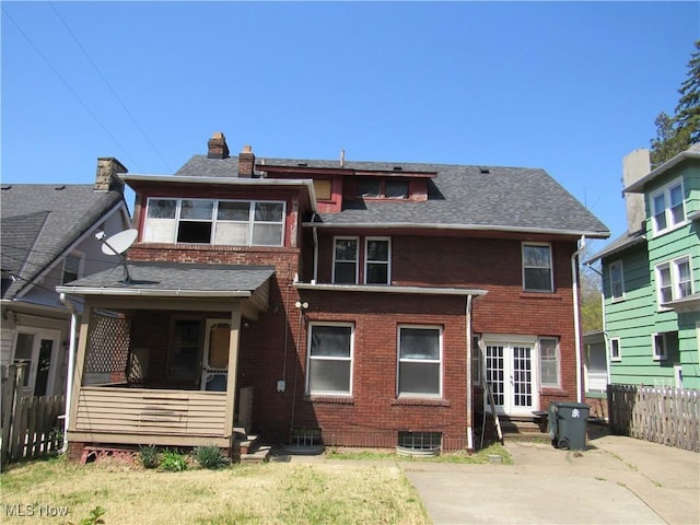 back of property with a chimney, fence, a shingled roof, a patio area, and brick siding