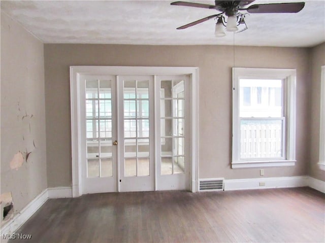 doorway featuring baseboards, a ceiling fan, wood finished floors, and visible vents