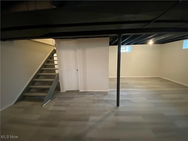 below grade area with stairway, baseboards, and wood finished floors