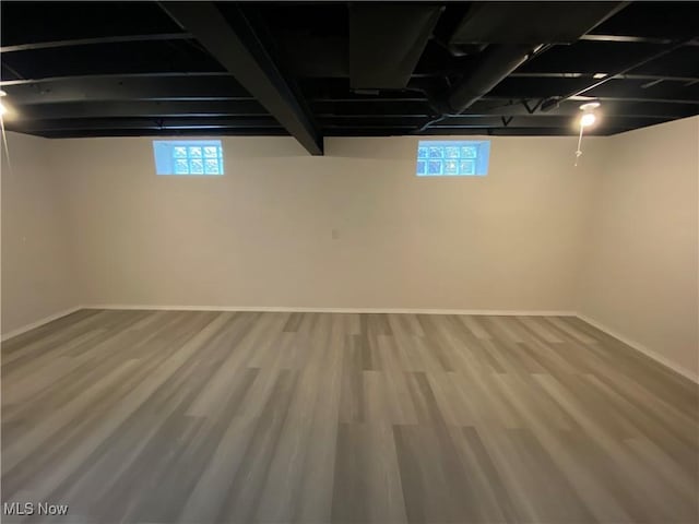 basement featuring wood finished floors and baseboards