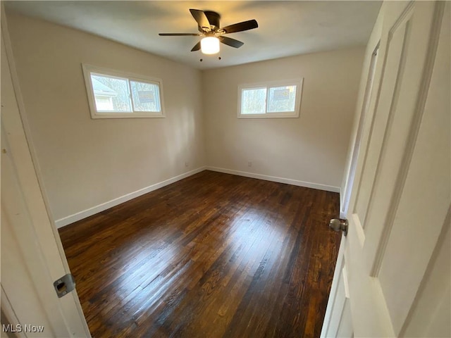 unfurnished bedroom with baseboards, a ceiling fan, and dark wood-type flooring