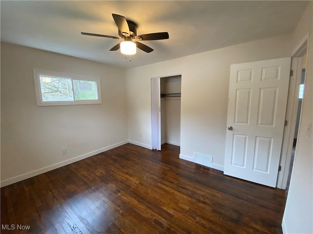 unfurnished bedroom featuring visible vents, a ceiling fan, a closet, baseboards, and dark wood-style flooring