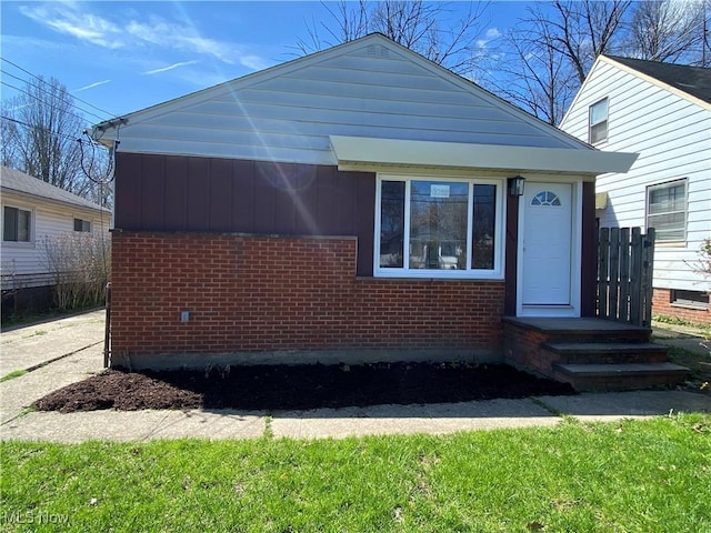 bungalow with brick siding and fence