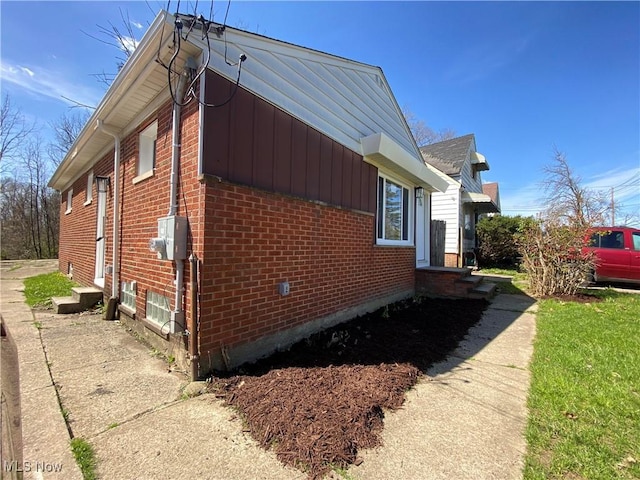 view of side of home featuring brick siding and entry steps