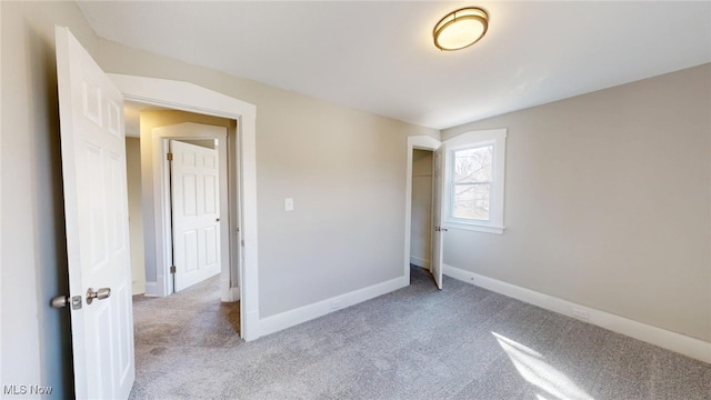 spare room featuring baseboards and carpet flooring