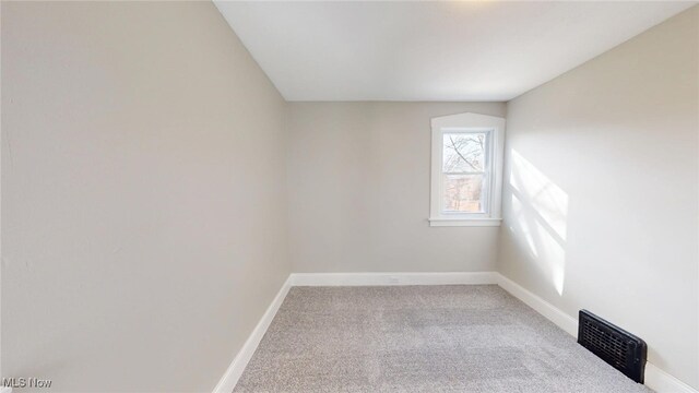 carpeted empty room with visible vents and baseboards