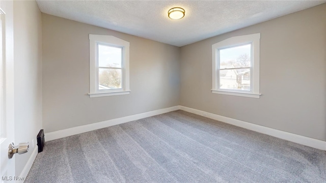 unfurnished room with baseboards, carpet floors, and a textured ceiling