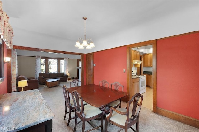 dining space with light carpet and a notable chandelier