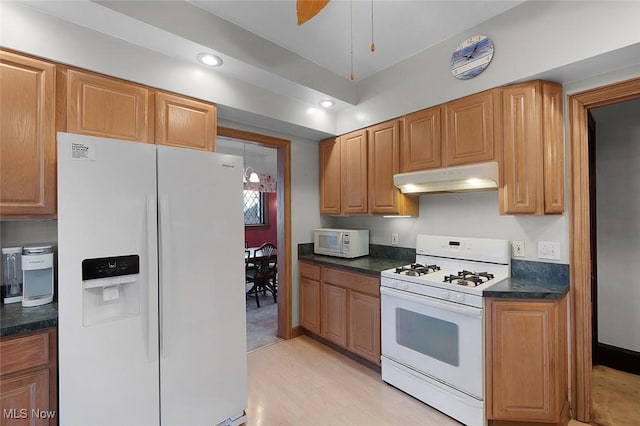 kitchen featuring recessed lighting, light wood-style flooring, under cabinet range hood, and white appliances