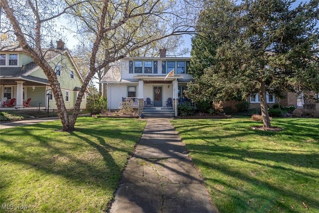 view of front of property featuring a chimney, covered porch, and a front yard