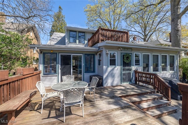 back of house with outdoor dining area and a deck