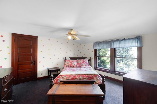 bedroom with wallpapered walls, dark colored carpet, baseboards, and ceiling fan