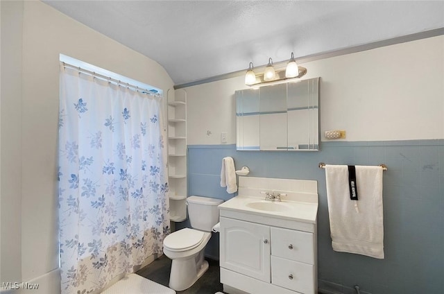 bathroom featuring vaulted ceiling, vanity, a shower with shower curtain, and toilet