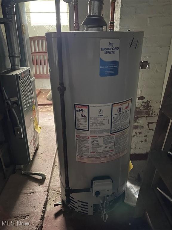 utility room with heating unit and gas water heater