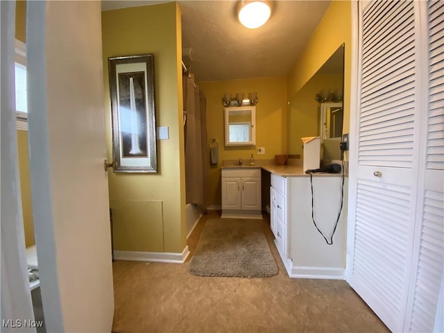 bathroom with baseboards, curtained shower, and vanity