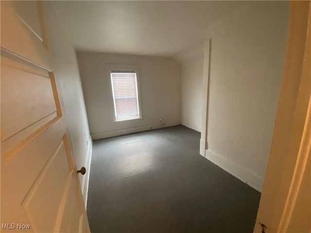 spare room with vaulted ceiling and baseboards