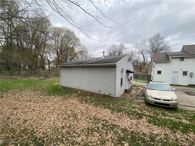 view of side of home with roof with shingles