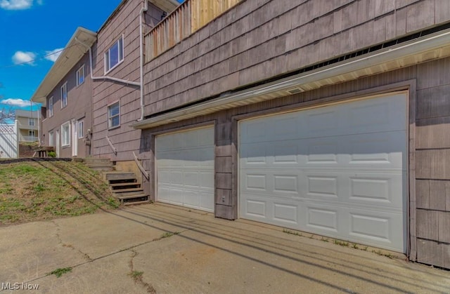 view of side of home with an attached garage and concrete driveway