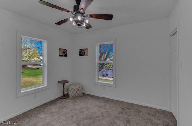unfurnished room featuring baseboards, a ceiling fan, and carpet