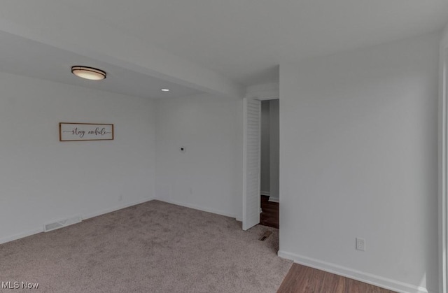 carpeted empty room featuring baseboards, visible vents, and recessed lighting