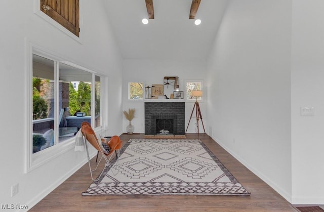 living area featuring baseboards, recessed lighting, high vaulted ceiling, wood finished floors, and a fireplace