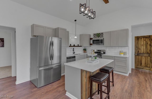kitchen featuring dark wood finished floors, appliances with stainless steel finishes, gray cabinetry, and a sink