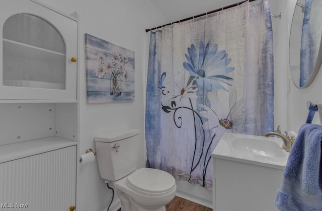 bathroom featuring wood finished floors, curtained shower, vanity, and toilet