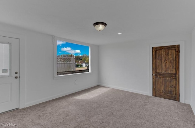 empty room with baseboards and carpet
