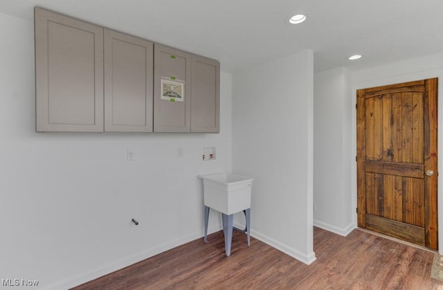 laundry room featuring recessed lighting, wood finished floors, baseboards, and laundry area