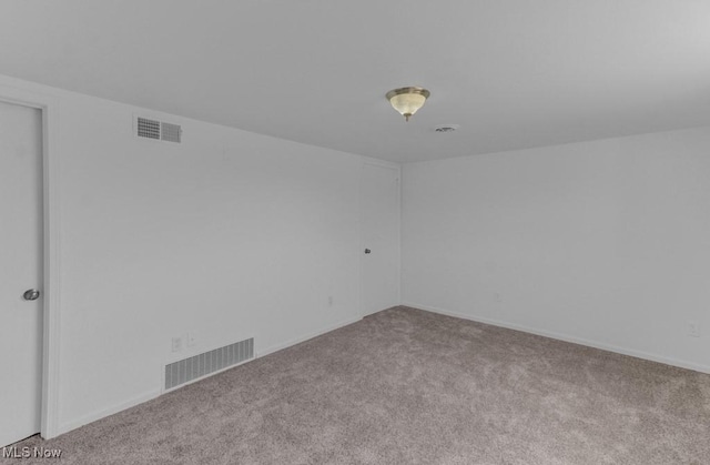 spare room featuring baseboards, carpet flooring, and visible vents