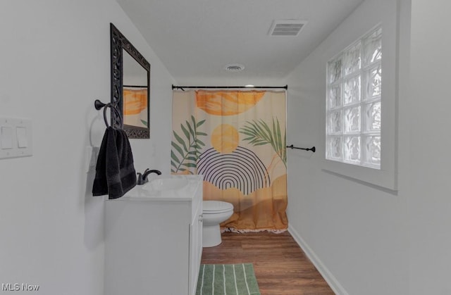 full bathroom featuring wood finished floors, visible vents, toilet, vanity, and baseboards