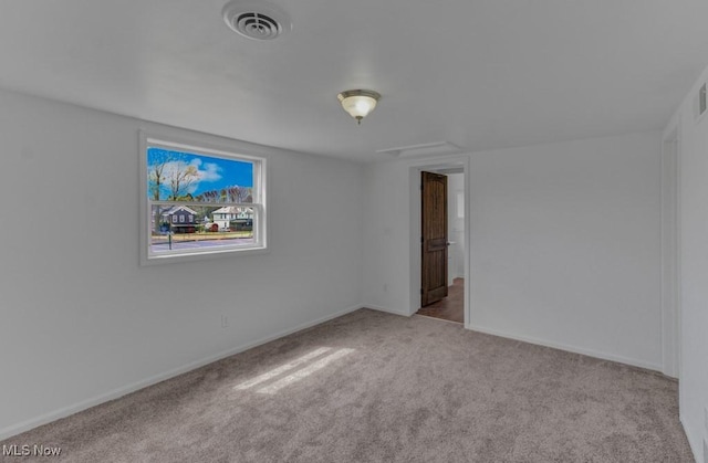 carpeted spare room with baseboards and visible vents