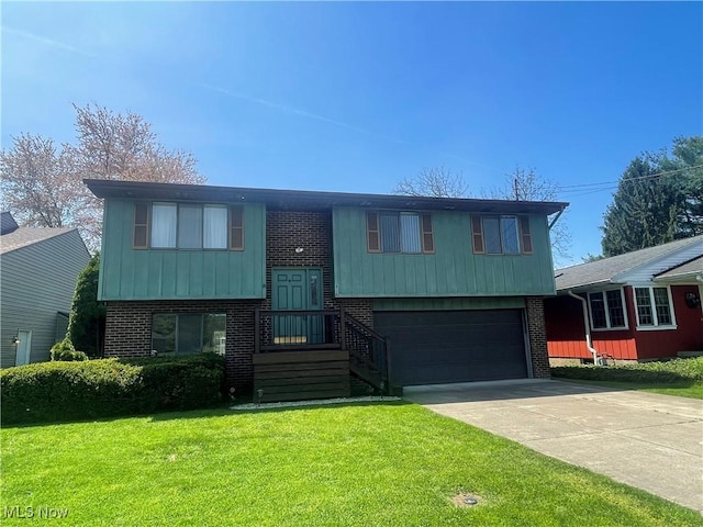 split foyer home featuring an attached garage, brick siding, driveway, and a front lawn