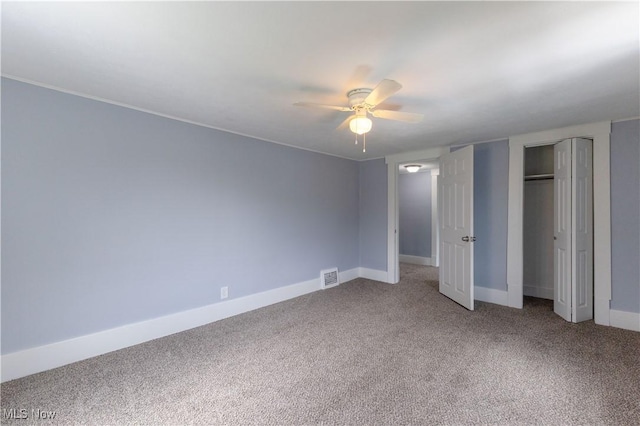unfurnished bedroom with baseboards, visible vents, a ceiling fan, and light colored carpet