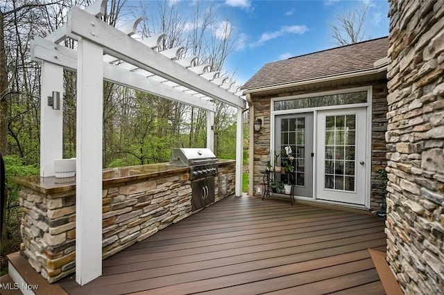 wooden terrace with an outdoor kitchen, grilling area, and a pergola