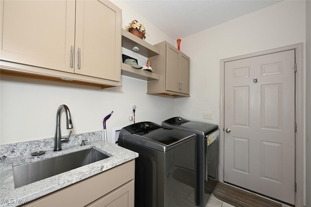 laundry room with washer and dryer, cabinet space, and a sink