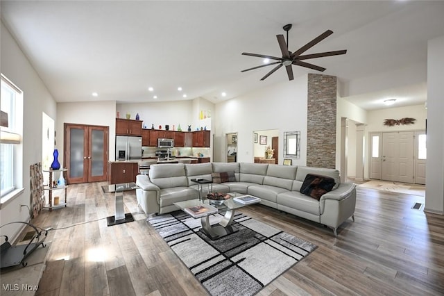 living area featuring plenty of natural light, high vaulted ceiling, and ceiling fan