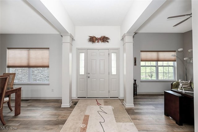 foyer featuring baseboards, decorative columns, wood finished floors, and a ceiling fan