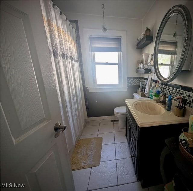 bathroom featuring a shower with shower curtain, toilet, vanity, and tile patterned floors