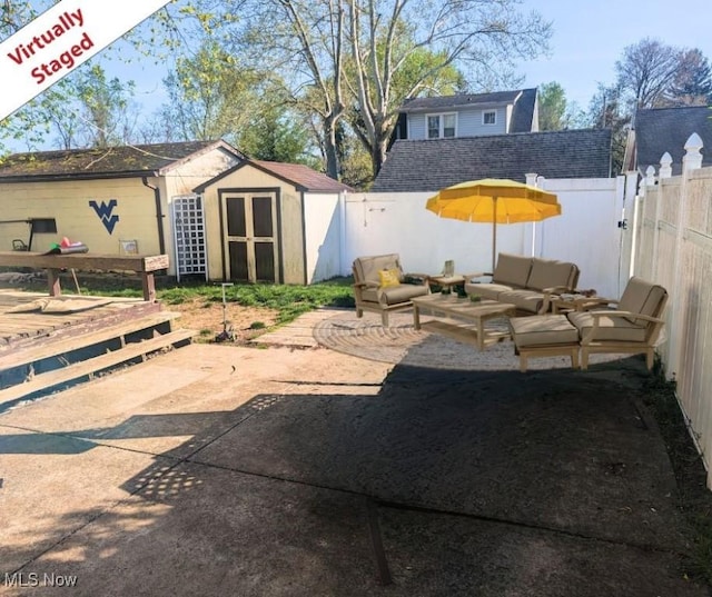 view of patio featuring an outdoor structure, a storage unit, an outdoor hangout area, and a fenced backyard