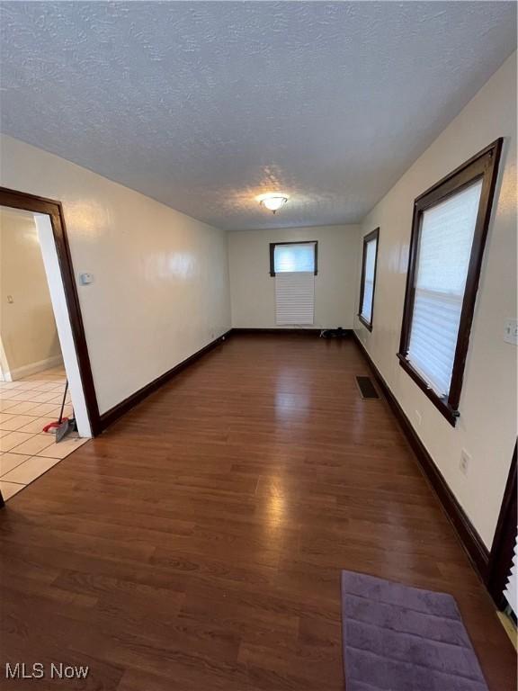 7706 Connecticut Ave, Garfield Heights, OH 44105 - empty room featuring visible vents, a textured ceiling, and dark wood-type flooring